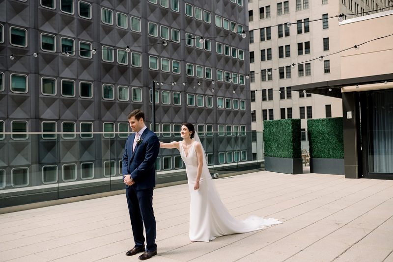Bride and groom first look session on hotel rooftop