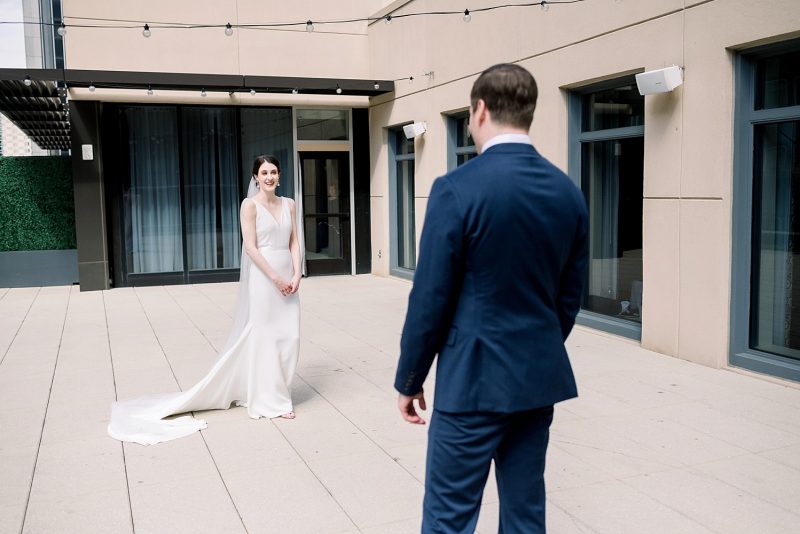 Bride and groom first look session on hotel rooftop