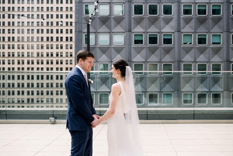 Bride and groom first look session on hotel rooftop